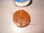 The LEDs are soldered to a piece of perf. board cut to fit into the old CFL casing.